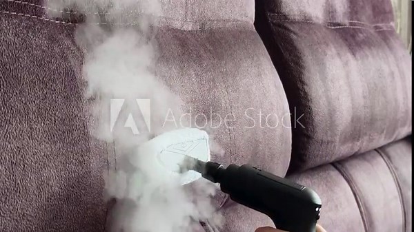 Cleaning upholstery in a living room using a steam cleaner for deep dirt removal Stock Video