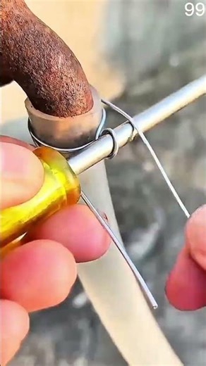Tightening hose clamp on plastic fitting with yellow screwdriver