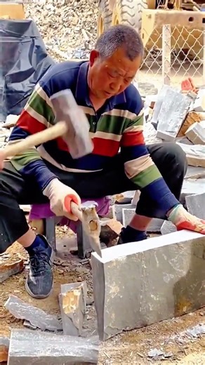 Skilled craftsman chiseling stone block with precision and strength