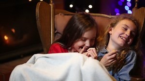 young girls laugh in the rocking chair