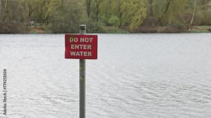red colour, do not enter water sign, by the side of a large lake, public warning concept, footage