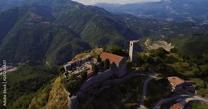 Aerial, medieval tower Rocca Di Sassi and a cemetery on top of the Apuan Alps in Tuscany, Italy