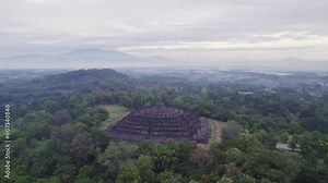 Cloudy morning view at Borobudur temple in Java. with in the distance Merapi volcano mountain, Aerial