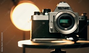 An old-fashioned, black and silver camera with big buttons and a round lens