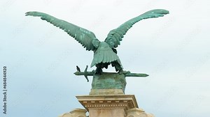 Rear view of eagle sculptures with sword against blue sky