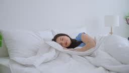 Asian beautiful woman lying down on bed in bedroom in morning at...