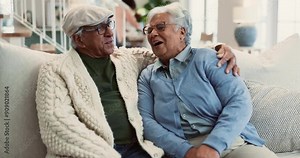 Senior, couple and kiss on sofa with love for marriage, commitment and romance in retirement. Elderly, people and embrace in home with laughing, happy and talking in living room for bonding or relax