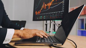 Download Financial Analyst Working on a Computer with Multi-Monitor Workstation with Real-Time Stocks, Commodities and Foreign Exchange Charts. Businessman Works in Investment Bank City Office at Night. for free
