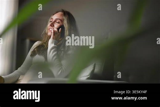 Young adult woman sitting in armchair in living room, having phone call, enjoying personal conversation, talking to friend, spending weekend time at home. Mobile connection and remote communication Stock Video Footage - Alamy