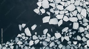 Kayak sailing between ice floes on Baikal lake in spring. Aerial drone view. Ice floes floating in the blue water. Baikal lake, Siberia, Russia.