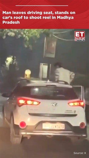 In a video sparking road safety concerns, a man left the driving seat while car was moving, stood on the roof to shoot reel in Madhya Pradesh. #MadhyaPradesh #RoadSafety #ETNOW | ET NOW