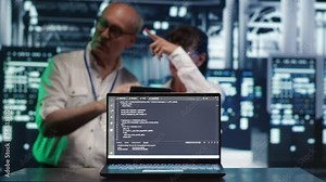 Cloud computing business executives solving tasks in data center, running scripts on laptop terminal. Knowledgeable IT team amidst servers, accessing databases and manipulating lines of code