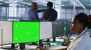 Technician using isolated screen computer, working in server farm to optimize it for data processing requirements. IT professional coding on chroma key PC in data center, camera A Stock Video