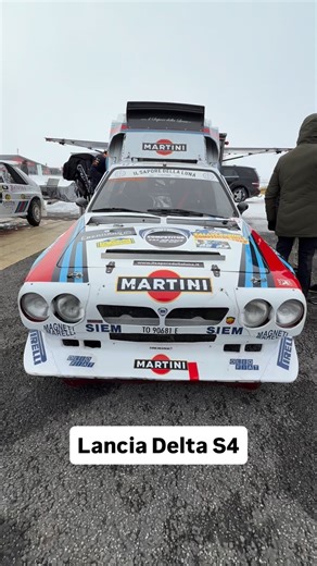 The Lancia Delta S4 is one of the most extreme machines ever built for rallying. Developed for the fearsome Group B era, it combined a supercharger and a turbocharger in a twin-charging system, delivering explosive power with almost no lag. With four-wheel drive, lightweight construction and brutal acceleration, the Delta S4 dominated on gravel, tarmac and snow alike. Its short but intense career made it a legend—raw, uncompromising, and forever linked to the wildest chapter in rally history. | 