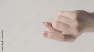 Vertical video. Come here. Invite gesture. Woman finger attracting beckoning hand sign isolated on gray empty space background.