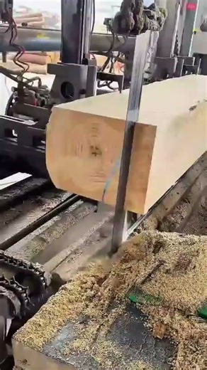 Cutting a wooden beam with a saw machine