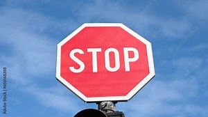Stop sign and red light at a traffic light at an intersection. Red stop sign on the road. Traffic sign along a city street.