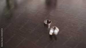 Spinning wedding rings, slow motion of rotating rings, close up dolly shot of turning wedding rings. Morning of the groom
