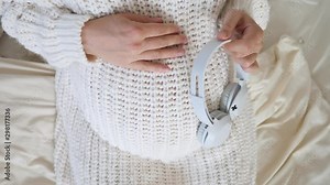 Music for Baby in Womb. Pregnant Woman Putting Headphones on Her Belly During Pregnancy.