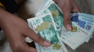 Counting Pakistani currency notes of 500 and 1000 Rupees in hands