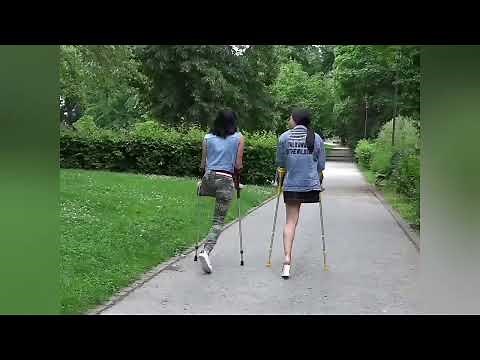 Girls with amputated legs challenge their disability by walking with crutches in the middleThe city