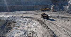 View of at opencast mining pit with lots of machinery escavators and trucks