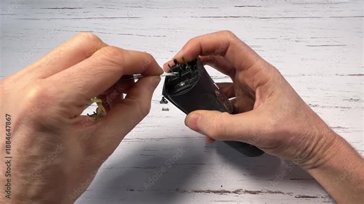 Disassembling a men's electric wireless razor and replacing old batteries - step 2 of 10, part of a series: removal of the swing frame springs and of the screws of the razor head support