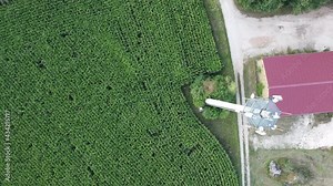 Ansbach, Germany Bavaria - August 22, 2020: Wide Area Network (WAN) 3G 4G 5G LTE mobile radio broadband transceiver communications tower with, corn field, building , and flyover from above.