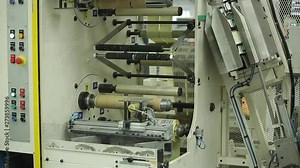 Multi Label Printing Rolls with High speed labeling machine in industrial factory and robotic machine, sticker on product in manufacture. Robotic Arm Assembling.