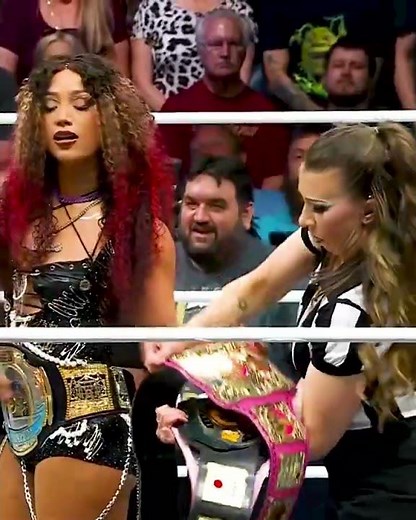 Mercedes Mone giving her 8 belts to refree before the match
