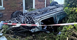 Car crashes into house with three people taken to hospital - in photos
