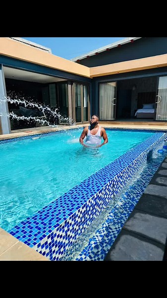 Adult Male Swimming and Splashing in Clear Pool