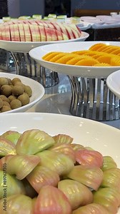 Various tropical fruits on a buffet table on white plates are cut. displayed for visitors. Fruit buffet