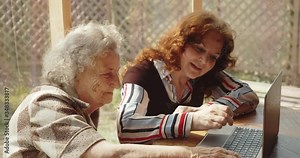 a woman teaches her elderly mother how to use a computer. positive and bright and fun. Stock Video