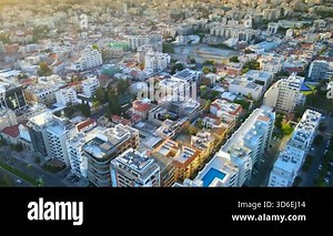 Aerial panoramic view of Limassol, Cyprus, highlighting the modern skyline, residential areas, and green spaces. The image captures the vibrant city life, urban development, and Mediterranean coastal atmosphere.