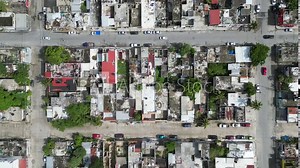 Aerial top-down view high altitude of slum a heavily populated urban informal settlement characterized by substandard housing and squalor poor living conditions streets and rusty metal home roof tops