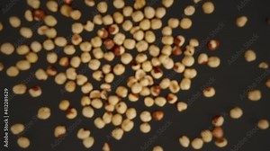 Slow motion of flying peeled hazelnuts a black background