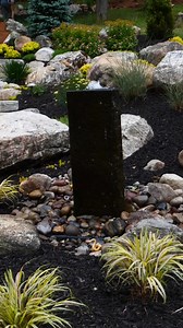 Bold. Natural. Timeless. Basalt column fountains make a statement while blending seamlessly into any landscape. Available in both real and faux basalt. #GardenFountain #BackyardDesign #OutdoorOasis | Garden State Koi Pond & Waterfall Design Center
