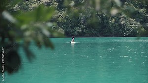 Young woman kneeling on a stand up paddle board enjoy paddleboarding in a lagoon