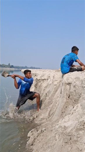 Two boys sitting by the river