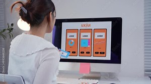 Young web designer is creating a mobile application, placing different wireframe elements on a screen