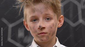 Shocked boy with dirty face shrugging shoulders, explosion at chemistry lesson