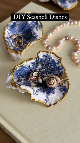 Sheri Wilson on Instagram: "DIY Seashell Dish 🐚 I’ve seen these all over social media and had to give it a try! They are so simple to make and perfect on a nightstand or dresser! Seashell necklaces- @fableengland You’ll need- Seashells (I found these at Walmart) Mod podge Gold paint Decorative napkins 1. Separate the backing from the napkin and cut out the piece you’d like to use inside the shell. 2. Paint a layer of mod podge inside the shell, then place the cutout napkin on top. Smooth the na