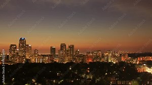 Toronto midtown skyline time lapse with sky getting dark, and urban lights causing red glow from light pollution over residential high rise condominium and apartment buildings and houses