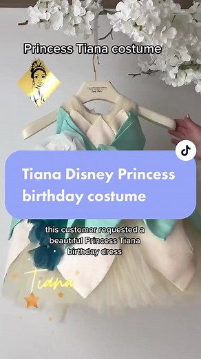 Tiana Disney Princess costume- first birthday party dress Your little princess is growing up and it's time to make her first birthday one to remember! What better way to commemorate this special milestone than by giving your daughter the experience of becoming their favorite Disney Princess, Tiana? With a gorgeous dress that embodies all of Tiana’s grace and class, she will feel like royalty. From the beautiful petal skirt that sweeps the floor delightfully to the handmade flower corsage at the