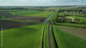 Following a train track in a Dutch polder landscape with a drone