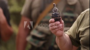 A realistic hand grenade or smoke grenade, high explosive TNT in the hand of a soldier