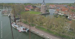 Aerial descending past sailing boats in in historic Dutch town Enkhuizen in North Holland the Netherlands