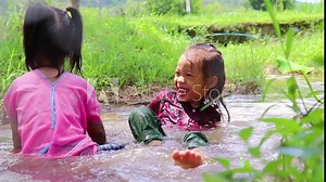 Children playing barefoot in stream water, play mud and sand. Stock Video