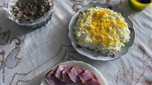 Festive Dishes of Christmas Table with Traditional Food. Chops, Salads, Rolls. Festive dishes are on the Christmas table. Fried fish, fried homemade sausage, cheese, mimosa salad, canned mushrooms.